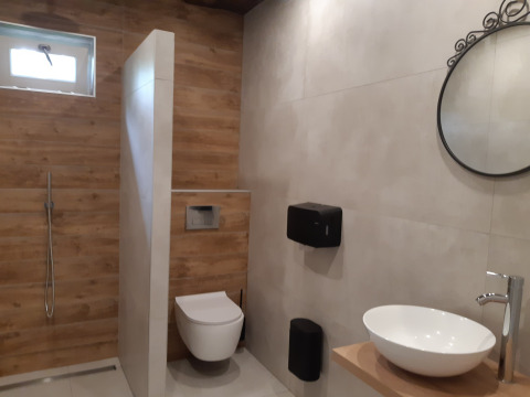 Moderne badkamer bij Minicamping Sint Jan - Safaritenten Zeeland met douche, toilet en stijlvolle wasbak.