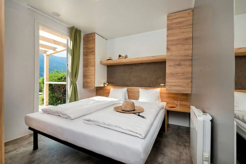 Bedroom in glamping accommodation at Wellnesscamping & Landhuis Parth with double bed and outdoor view