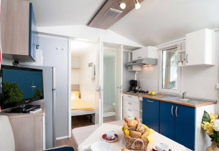 Hébergement glamping moderne avec cuisine, coin repas, chambre et TV au Wellnesscamping & Landhuis Parth.