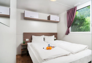 Moderne glampingaccommodatie bij Wellnesscamping & Landhuis Parth met comfortabel bed en uitzicht op natuur.