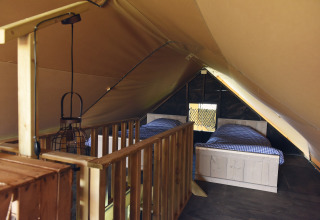 Intérieur grenier sous tente avec deux lits simples à Duynpark Het Zwanenwater - Woodlodges Noord-Holland, glamping.