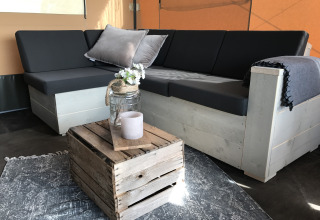 Espace salon de glamping aux Woodlodges Duynpark Het Zwanenwater, Noord-Holland, au style rustique.