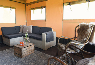 Salón de glamping acogedor de Duynpark Het Zwanenwater Woodlodges Noord-Holland con decoración rústica.