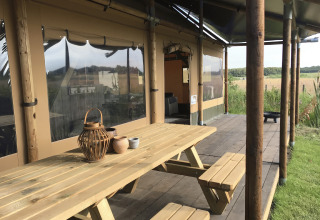 Buitenveranda bij Duynpark Het Zwanenwater - Woodlodges Noord-Holland met picknicktafel en natuurrijk uitzicht.