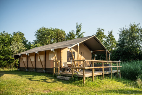 Hébergement glamping à Erfgoed Bossem - Lodgetenten Twente, grande tente safari avec terrasse bois.