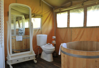Luxuriöse Glamping-Unterkunft bei Erfgoed Bossem Lodgetenten Twente mit Badewanne und Spiegel.