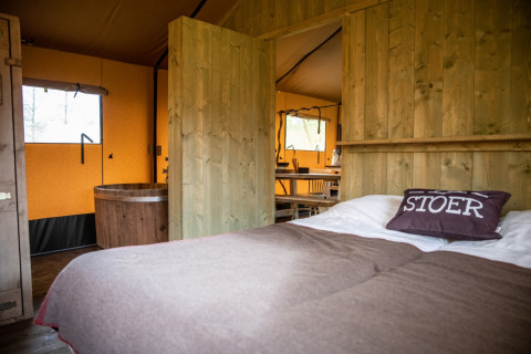 Intérieur chaleureux d'une tente glamping à Erfgoed Bossem - Lodgetenten Twente aux Pays-Bas.