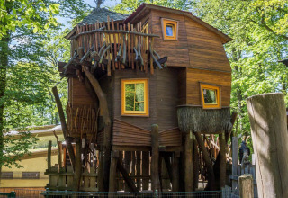 Alojamiento glamping único en casa del árbol en Dierentuin Schwerin, rodeado de naturaleza y árboles.