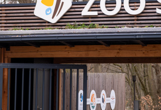 Ingresso dello zoo di Schwerin con insegna moderna, ideale per glamping o campeggio presso Boomhut.