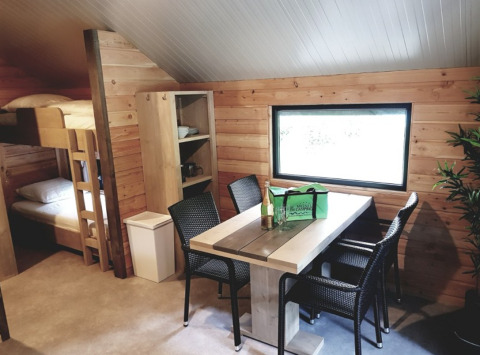 Interieur van glamping accommodatie bij Camping Alf - Chalets Rijnland-Palts met stapelbedden en eettafel.
