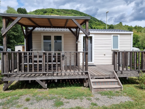 Glamping accommodation at Camping Alf - Chalets Rhineland-Palatinate with wooden deck and hill behind.