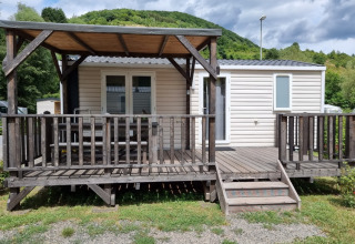 Glamping indkvartering på Camping Alf - Chalets Rijnland-Palts med træterrasse og bjergbaggrund.