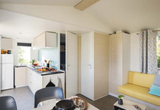 Interieur van glamping accommodatie bij Camping Alf - Chalets Rijnland-Palts met keuken en gele bank.