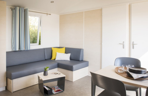 Alloggio glamping moderno al Camping Alf - Chalets Rijnland-Palts, con salotto accogliente e tavolo da pranzo.