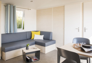 Modern glamping accommodation at Camping Alf - Chalets Rijnland-Palts, with cozy seating area and dining table.