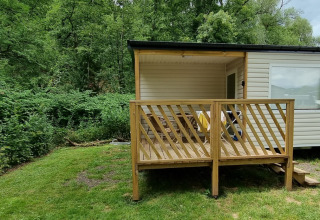 Terrasse en bois d'un hébergement glamping au Camping Alf - Chalets Rijnland-Palts, entouré de forêt.