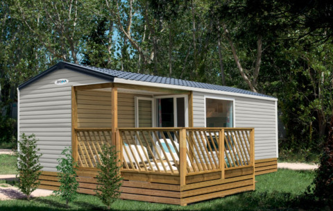 Glamping accommodation at Camping Alf - Chalets Rijnland-Palts, mobile home with deck in forest setting.