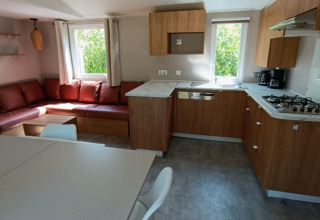 Moderne Glamping-Unterkunft mit Holzküche, Ecksofa und großen Fenstern bei Camping Alf - Chalets Rijnland-Palts.