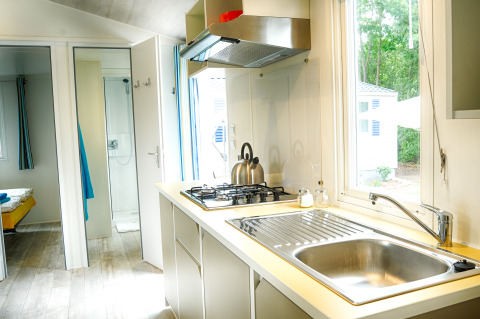 Cocina moderna con estufa y fregadero en caravana de lujo en Camping Nahemühle, Renania-Palatinado.