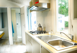 Cucina moderna con fornello e lavello in una casa mobile di lusso al Camping Nahemühle in Renania.