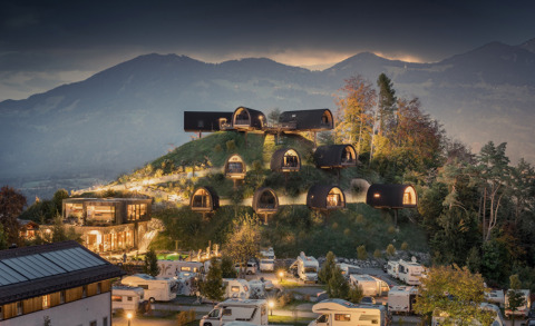 Heuveltop met luxe glampingchalets en campers bij valavond op Alpencamping Nenzing in Voralberg, Oostenrijk.