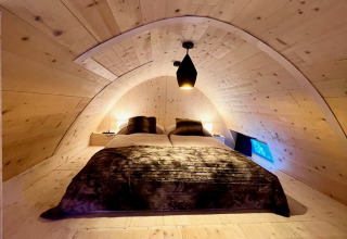 Premium chalet at Alpencamping Nenzing in Vorarlberg featuring a cozy wooden bedroom with soft lighting.