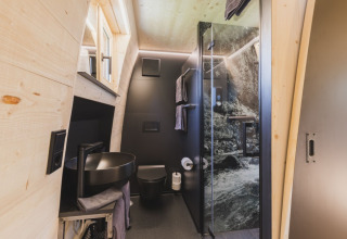 Modern bathroom in Alpencamping Nenzing premium chalet, Vorarlberg, with sleek black fixtures and nature-inspired shower.