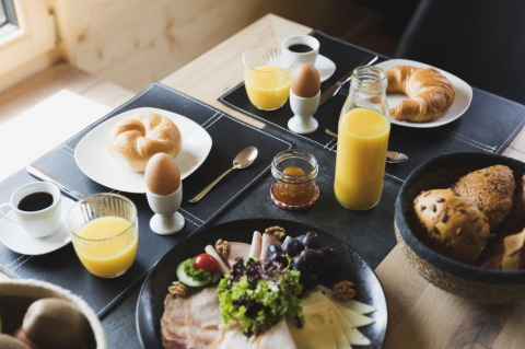 Uitgebreid ontbijt met sap, koffie, broodjes en eieren bij Alpencamping Nenzing Premium chalet in Vorarlberg.