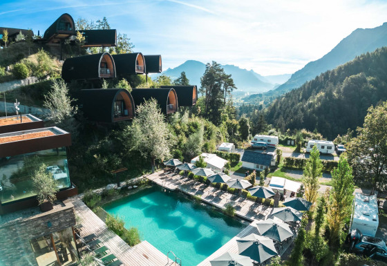 Panorama su Alpencamping Nenzing con chalet premium, piscina e montagne in Vorarlberg, ideale per glamping.