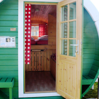 Grünes Campingfass mit geöffneter Tür bei Camping Ostseequelle- Wijnvaten Ostzee, Deutschland, Glamping.