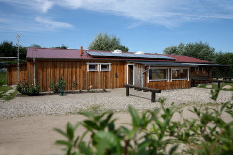 Alojamiento glamping en Camping Ostseequelle, Wijnvaten Ostzee, Alemania, con cabaña de madera y cielos claros.