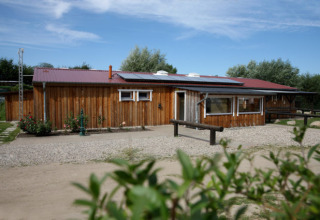 Glamping-indkvartering ved Camping Ostseequelle, Wijnvaten Ostzee, Tyskland, med træhytte og blå himmel.