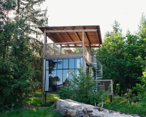 Glampingaccommodatie Nutchel Cabins - Tiny Houses Elzas, moderne boscabine met glazen wanden en terras.