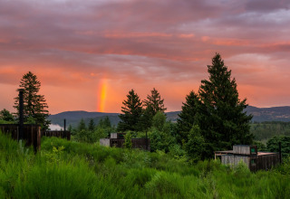 Nutchel Cabins Tiny Houses Elzas circondate dal verde, tramonto e arcobaleno in cielo, alloggio glamping.