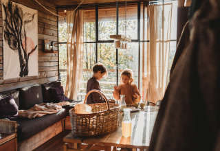 Two kids enjoy their time inside Nutchel Cabins - Tiny Houses Elzas, a cozy glamping accommodation in nature.