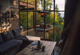 Gemütliches Wohnzimmer in Nutchel Cabins - Tiny Houses Elzas mit großem Fensterblick aufs Grüne.