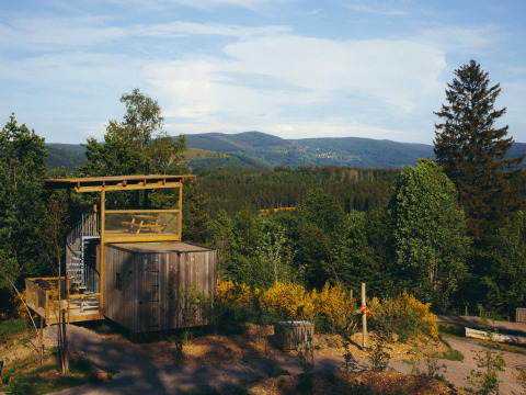 Nutchel Cabins - Tiny Houses Elzas: glamping tra foreste verdi e montagne sotto un cielo luminoso.