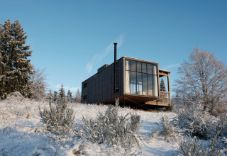 Nutchel Cabins - Tiny Houses Elzas, alojamiento glamping, moderna cabaña de madera en paisaje nevado.