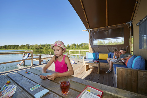 Familia disfrutando en WaterLodges Brabant de Recreatiepark TerSpegelt, jugando junto al lago.