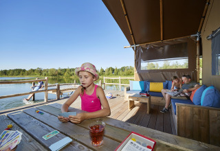 Familie hygger sig i WaterLodges Brabant på Recreatiepark TerSpegelt, leger og slapper af ved søen.