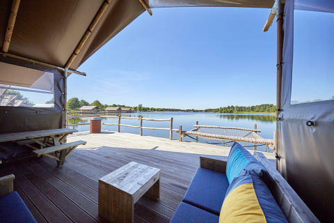 Glamping ved vandet på Recreatiepark TerSpegelt WaterLodges Brabant med terrasse, udsigt og hængekøje.