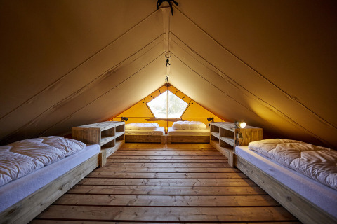 Interieur van een glamping tent bij Recreatiepark TerSpegelt WaterLodges Brabant met vier bedden.