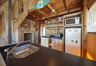 Cocina de glamping rústica en WaterLodge de Recreatiepark TerSpegelt, Brabant, con interior de madera.