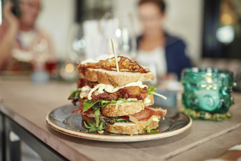Mehrschichtiger Sandwich auf einem Teller in moderner Umgebung bei Recreatiepark TerSpegelt WaterLodges Brabant.