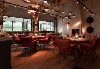 Interno ristorante moderno presso Recreatiepark TerSpegelt WaterLodges Brabant con arredi caldi ed eleganti.