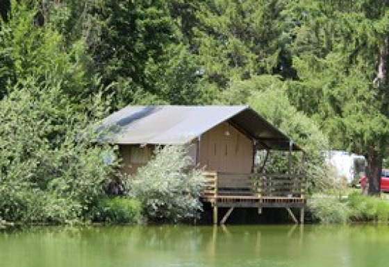 Hébergement glamping au bord d’un lac entouré d’arbres au Camping Ammertal - Lodges Beieren en Bavière.
