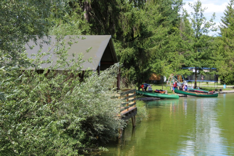 Glamping accommodatie aan het meer bij Camping Ammertal - Lodges Beieren met kano's en bomen.