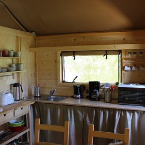 Angolo cottura in legno all'interno di una tenda glamping presso Camping Ammertal - Lodges Beieren.