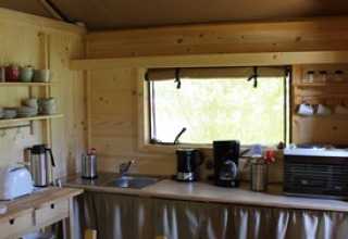 Acogedora cocina de madera en un alojamiento glamping en Camping Ammertal - Lodges Beieren con ventana.