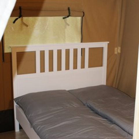 Interno di alloggio glamping al Camping Ammertal - Lodges Beieren con letto matrimoniale.